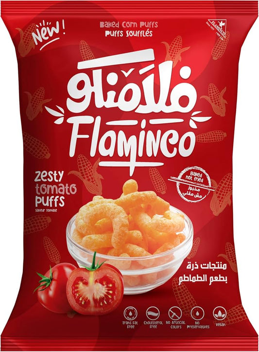 A red bag of Flaminco Zesty Tomato Puffs, featuring a bowl of golden-orange puffs and fresh tomato graphics on the front, with the brand name 'Flaminco' prominently displayed in white Arabic script.